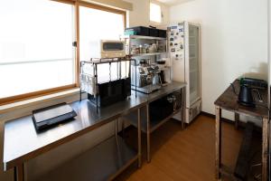 a kitchen with a table with a microwave and a refrigerator at TANIGAWA GOODY Lodge in Minakami