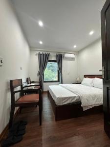 a bedroom with a bed and a chair and a window at Bích Giản Tràng An in Nguyên Ngoại