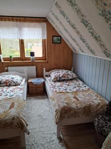 a bedroom with two beds and a window at Olsik in Białowieża