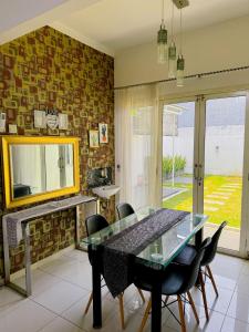 a dining room with a glass table and chairs at Arcovella House in Cikarang
