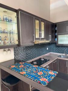 a kitchen with a counter with a flower pattern on it at Arcovella House in Cikarang +3 photos