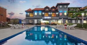 a swimming pool in front of a building at Taean janggog pension in Taean