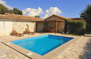 a swimming pool in front of a house at Holiday Home Sandra in Sveti Lovreč Pazenatički