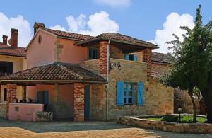 a large brick house with a blue window at Holiday Home Sandra in Sveti Lovreč Pazenatički
