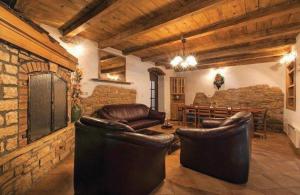 a living room with leather furniture and a brick wall at Holiday Home Sandra in Sveti Lovreč Pazenatički
