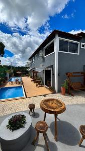 a house with a patio with a pool and tables at Pousada Coco Babaçu in Viçosa do Ceará