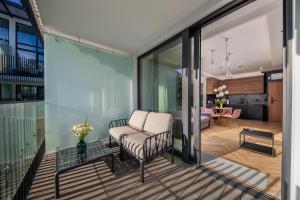 a balcony with a chair and a living room at Apartament Bursztynowa Komnata 117 Stegna nad morzem in Stegna +44 photos