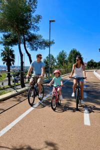 two adults and a child riding bikes down a road at Casa Mare Blu in Imperia