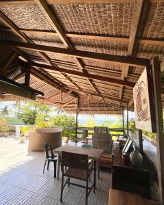 a patio with a table and chairs under a wooden ceiling at Patrick's on the Beach Resort in General Luna
