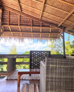 a table and chairs on a porch with a roof at Patrick's on the Beach Resort in General Luna