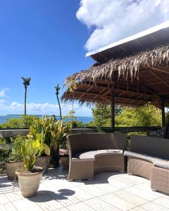 a patio with a bench and a straw umbrella at Patrick's on the Beach Resort in General Luna