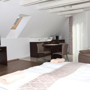 um quarto com uma cama, uma secretária e uma mesa em Viktória Vendégház em Eplény