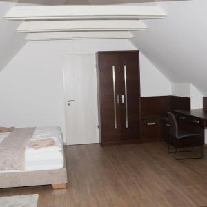 a bedroom with a bed and a desk and a chair at Viktória Vendégház in Eplény