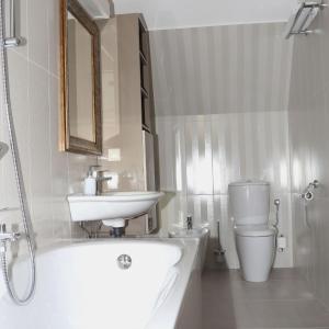 a bathroom with a tub and a sink and a toilet at Viktória Vendégház in Eplény +11 photos