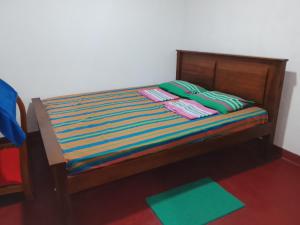 a small bed with colorful sheets and pillows on it at Duleni villa in Haldummulla +10 photos
