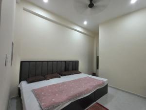 a bedroom with a large bed with a pink blanket at Pramod Residency in Chitrakoot