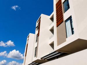 a white building with a blue sky in the background at Studio 213 - Ebene Square in Ebene +9 photos