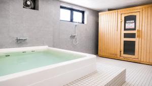 a bath tub in a bathroom with a window at Center Hotel Mihara in Mihara