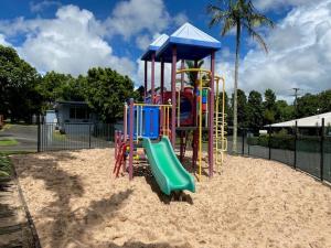 a playground with a slide in the sand at Atherton Tourist Park in Atherton