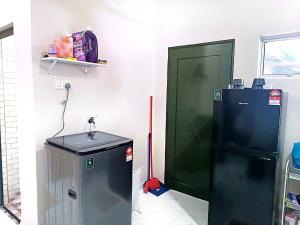a room with a green door and a refrigerator at Adeeb Homestay in Tumpat