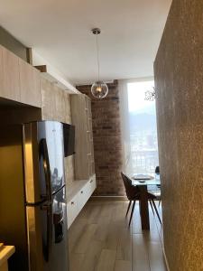 a kitchen with a stainless steel refrigerator and a table at Apartment luxury and comfort in Monterrey