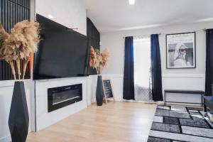 a living room with a tv and a fireplace at Jacuzzi Cul de Sac Home in Country Club Hills