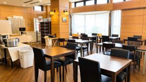 a restaurant with tables and chairs in a room at Center Hotel Mihara in Mihara