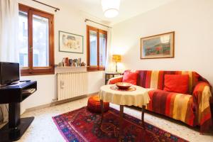 Campiello Chiesa, Venezia by Short Holidays في البندقية: غرفة معيشة مع أريكة وطاولة