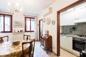 eine Küche und ein Esszimmer mit einem Tisch und Stühlen in der Unterkunft Campiello Chiesa, Venezia by Short Holidays in Venedig