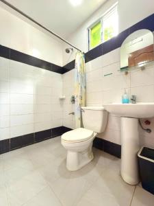 a bathroom with a toilet and a sink at Buena's Haven Travelodge in El Nido