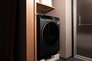 a black washer and dryer in a bathroom at Tousumi in Fukuoka