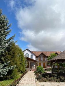 a house with a brick walkway in a yard at Green House in Cholpon-Ata
