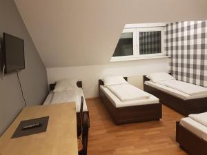 ワルシャワにあるDuszka Hostelのベッド2台とテーブルが備わる小さな客室です。