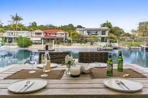 a wooden table with plates and wine bottles on it at Key Court 17 in Noosa Heads