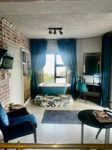 a bathroom with a tub and blue curtains at Welgemoed Villa in Bellville