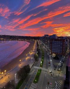 a view of a beach at dusk with a sunset at Hospedaje Boutique Weber's in Gijón