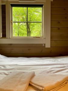 a bed in a bedroom with a window at Cozy log cabin in Geiranger in Geiranger