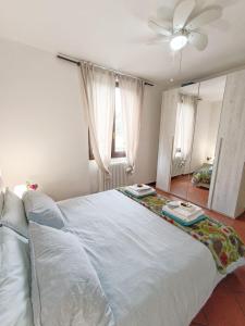 a bedroom with a large white bed with a ceiling fan at Casa Anna in Lierna