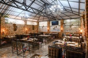 a restaurant with tables and chairs in a room at Art Hotel Al Hayat in Kaji-Say