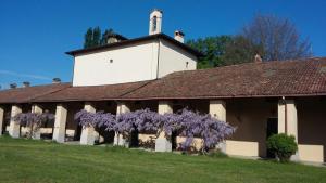 San Colombano al Lambro的住宿－Agriturismo San Bruno，前面有紫色紫藤的建筑