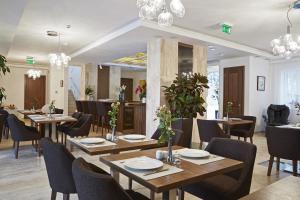restauracja z drewnianymi stołami, krzesłami i kwiatami w obiekcie Botrytis Borhotel w mieście Mád