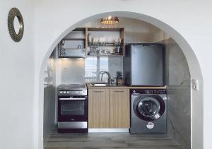 a kitchen with an archway with a washer and a washing machine at Thalassa Beach Kavala in Paleo Tsifliki