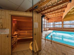 une piscine intérieure avec sauna dans un bâtiment dans l'établissement Noemys Ecrin des Neiges, à Chamrousse