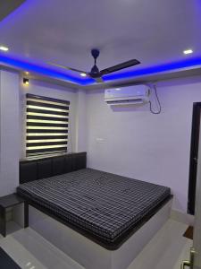 a bed in a room with a blue light at Mandapam Hotel & Restaurant in Dhanbād