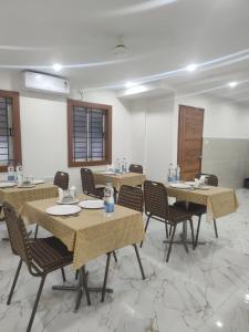 a large room with tables and chairs and a room with windows at Sri Sai Comforts Manyata Tech Park in Bangalore