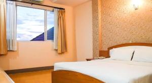 a bedroom with a bed and a window at Phuthong Place in Phayao +46 photos