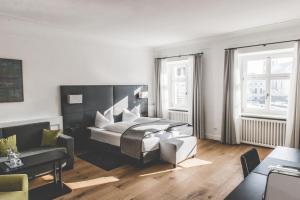 a living room with a bed and a couch at Hotel Münchner Hof in Altötting