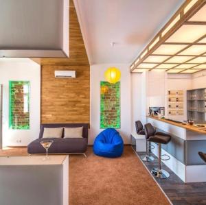 a living room with a blue couch and a kitchen at VIP apartment 40 in Lviv