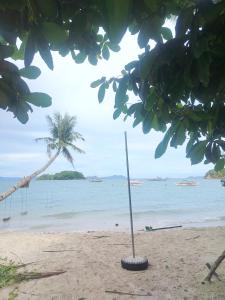 a pole in the sand on a beach with a palm tree at Mamatitas in San Vicente