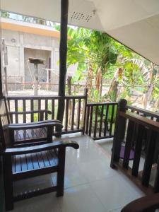 two benches on a balcony with a view of a building at Mamatitas in San Vicente